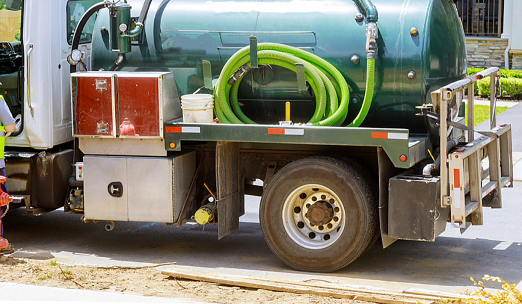 Vacuum loading truck equipped with hoses for industrial liquid waste removal and site cleaning.